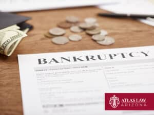 Bankruptcy form with cash and coins on a wooden table.