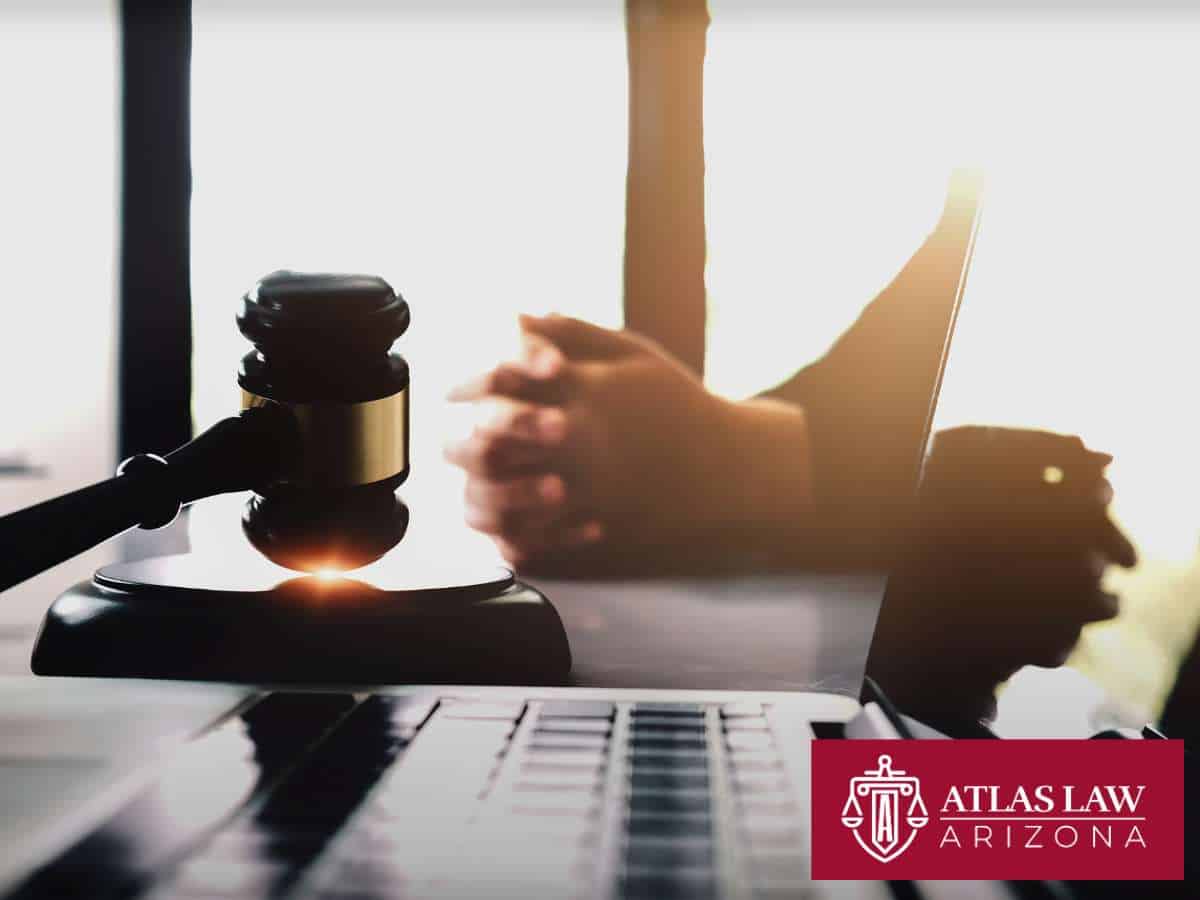 Close-up of gavel and laptop with hands in the background, representing an Arizona bankruptcy lawyer consultation.