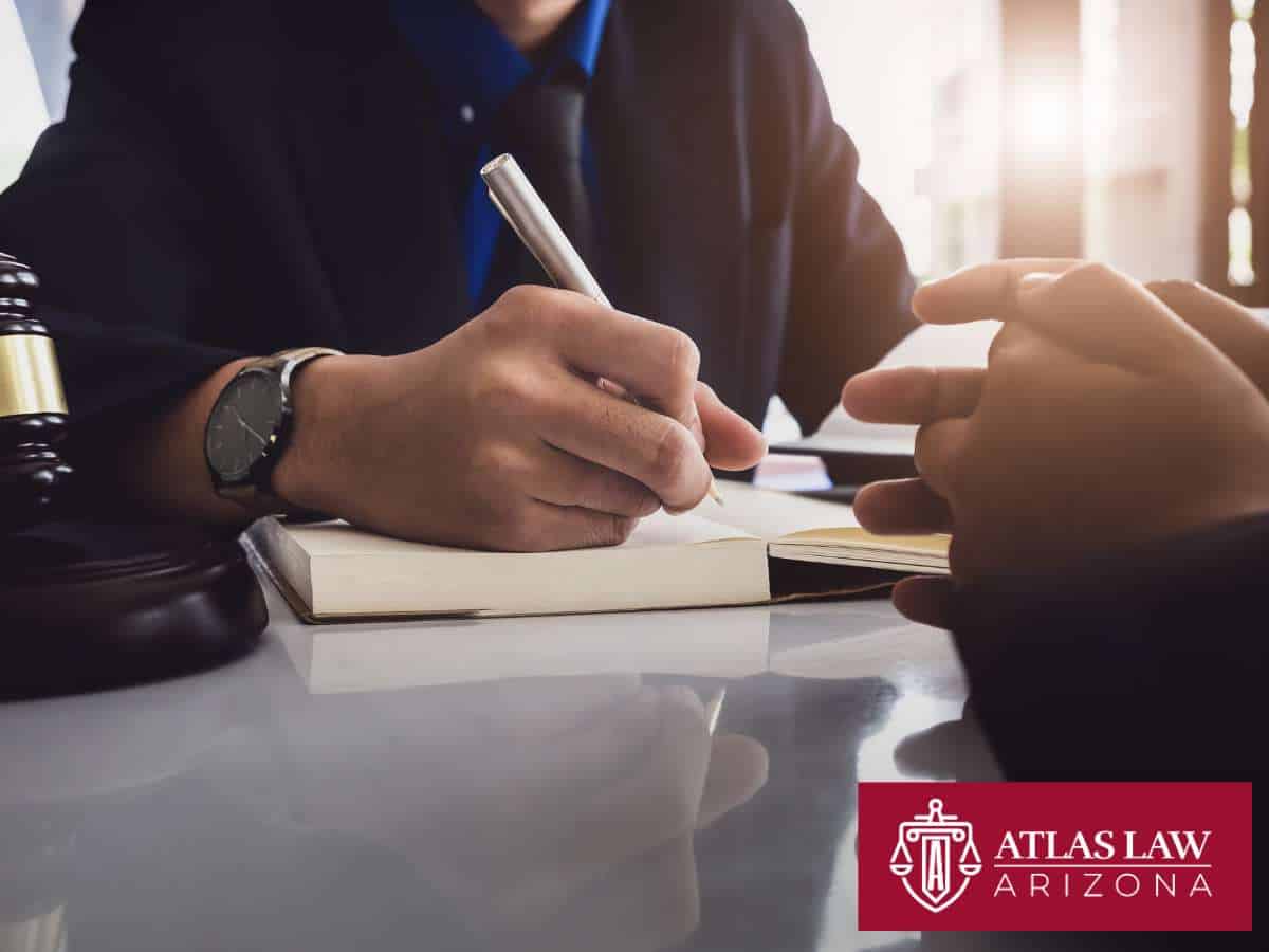 Arizona bankruptcy lawyer discussing financial solutions with a client at a desk with gavel and notebook.